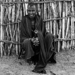 A Maasai man in contemplation in front of his hut (image by Oliver Krueger)