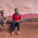 Borana children sitting outside their clay sculpted 'town' home near Marsabit (image by Inger Vandyke)