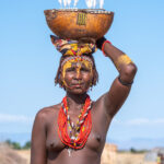 A decorated Dassanech woman carrying a ceremonial gourd to the celebration of Micha (image by Inger Vandyke)