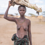 A Diyes woman carring a crocodile skull in remote northern Lake Turkana (image by Inger Vandyke)