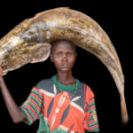 A Diyes woman carrying a gigantic Nile Perch, estimated to weigh around 50KG! (image by Inger Vandyke)