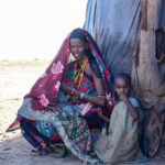 A Gabra woman breastfeeding with her daughter beside her (image by Inger Vandyke)