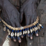 An elderly Pokot woman holding her cowrie shell headdress (image by Inger Vandyke)