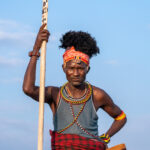 A Turkana elder holding his seat and a boat oar on the shore of Lake Turkana (image by Inger Vandyke)