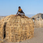 A Turkana woman building a traditional El Molo house. Her husband is from El Molo culture (image by Inger Vandyke)