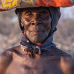 Portrait of an elderly Ovakuvale woman carrying a load of blankets (image by Inger Vandyke)