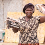 A fisherwoman showing off her dried fish (image by Inger Vandyke)