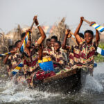 On our way back to the mainland from Ganvie, we were accompanied by a boat of boys, singing, dancing, and splashing water, adding an energetic and lively touch to our journey (image by Ingrid Koedood)