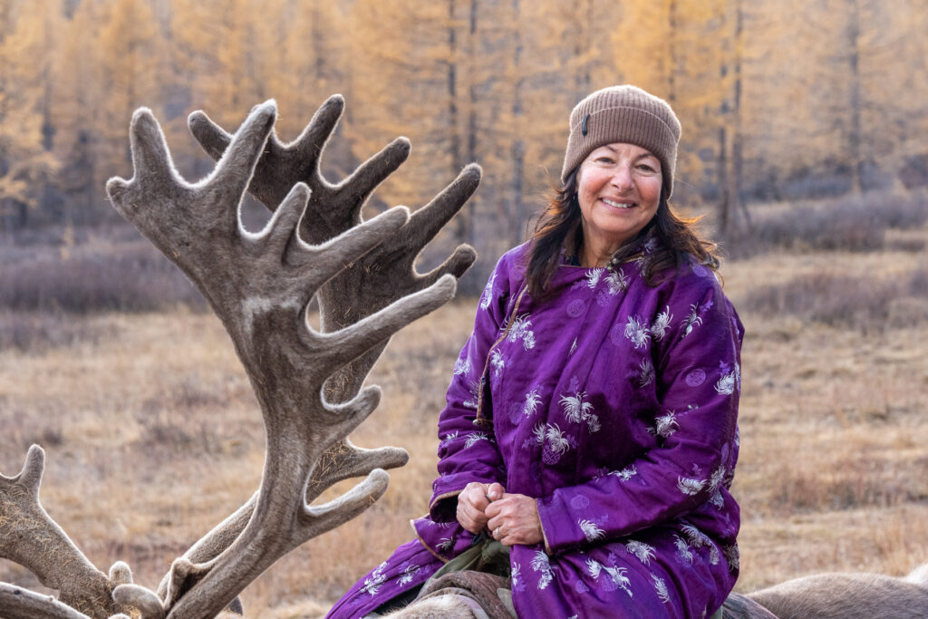 Wild Images guest Michelle looking very happy to have the chance of finally riding a reindeer (image by Inger Vandyke)