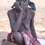 An older Ovatwa woman contemplates the activities in her community (image by Inger Vandyke)