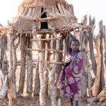 A young Ovahakaon girl standing next to the chicken house of her village (image by Inger Vandyke)