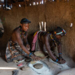Ovahakaona girls grinding grain inside their home (image by Inger Vandyke)