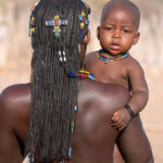 An Ovahakaona baby looks over the shoulder of his mother (image by Inger Vandyke)