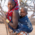 A young Ovakuvale mother carrying her young son (image by Inger Vandyke)