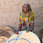 An Ovamwila woman sitting in her baskets (image by Inger Vandyke)