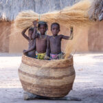 A group of Ovandimba children play in a large grain basket (image by Inger Vandyke)