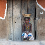 A pretty Ovandimba girl with a handwoven basket on her head (image by Inger Vandyke)