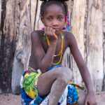 Portrait of an Ovandimba girl with a handwoven basket on her head (image by Inger Vandyke)