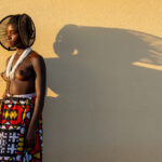 An Ovankhumbi girl with her spiral hairstyle dropping an amazing shadow (image by Inger Vandyke)