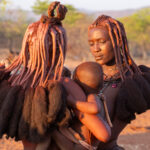 Ovatwa mothers care for an infant at sunset (image by Inger Vandyke)