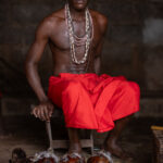 Portrait of a Shango priest behind the offerings to the Shango deity including human skulls, candles and a Shango doll (image by Ingrid Koedood)