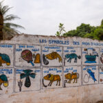 Picture of a wall with the symbols of the kings of Abomey. Symbolry is an important feature of street and building art in Benin (image by Ingrid Koedood)