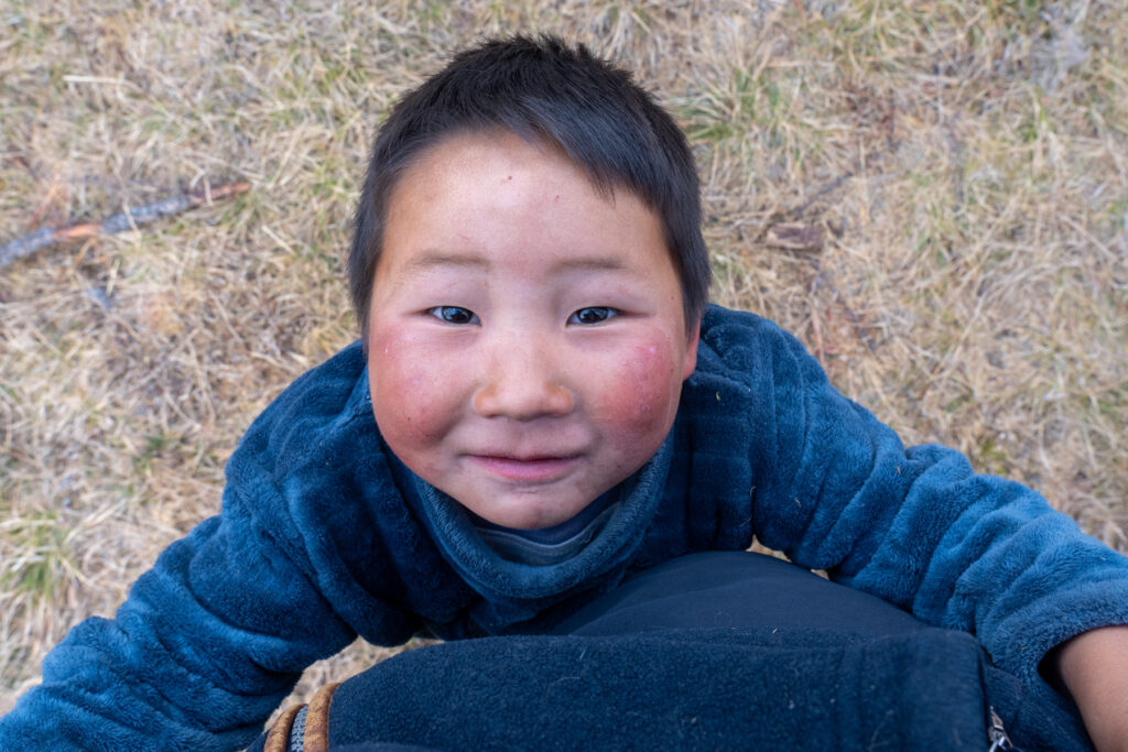 A young Tsaatan boy clings to Inger's legs in his community (image by Inger Vandyke)