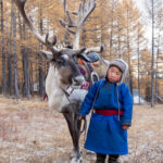 A young Tsaatan boy aged about four, with his reindeer of the same age (image by Inger Vandyke)
