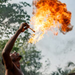 A Zangbeto devotee breathes fire into teh air during a dusk ceremony (image by Ingrid Koedood)