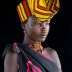 A young Jie woman wearing a crown of beads, the colour of which tie her to her husband's clan (image by Inger Vandyke)