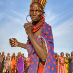 Jie woman breaks from the crowd to dance on her own at a ceremony (image by Inger Vandyke)