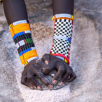 Even when they grind grain, Laarim women wear amazing jewellery (image by Inger Vandyke)