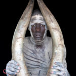 Portrait of a Mundari man with the gigantic horns of an Ankole Watusi cow (image by Inger Vandyke)