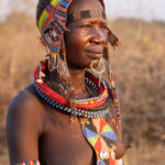 Beautiful Toposa woman with lip piercing, scarification and jewellery at sunset (image by Inger Vandyke)