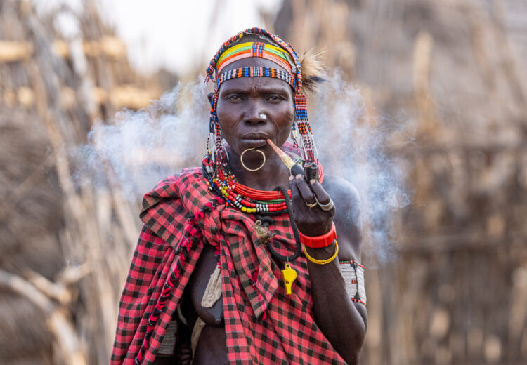 A Toposa woman exhales smoke from her Ijoo (image by Inger Vandyke)