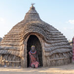 Toposa women standing outside one of their stunning homes. They are responsible for constructing these whimsical houses (image by Inger Vandyke)