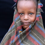 Wrapped in a thick shawl, only the face of this Arbore emerges with curious eyes (image by Ingrid Koedood)