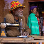 A tailor working behind a sewing machine with only one arm at the Dorze market (image by Ingrid Koedood)