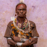 An elder Hamer woman stands gracefully against one of the vibrant walls of the Turmi market (image by Ingrid Koedood)