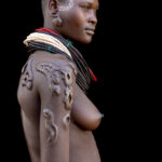 A Karo woman with scarification on her arms and shoulders. Scarification involves making small cuts on the skin, which are then filled with ash to create raised scars (image by Ingrid Koedood)