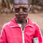 A cute young boy proudly shows off his handmade glasses, offering them as a unique souvenir from the village of Konso (image by Ingrid Koedood)