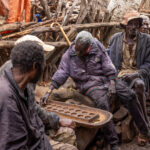 Men engage in a strategic game of Mancala, a timeless African pastime that challenges both skills and patience (image by Ingrid Koedood)