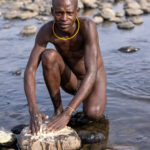A Suri boy prepares the paint made of clay and water to decorate his body and face (image by Ingrid Koedood)
