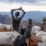 In the early morning, a Suri boy stretches, embracing the start of the day (image by Ingrid Koedood)