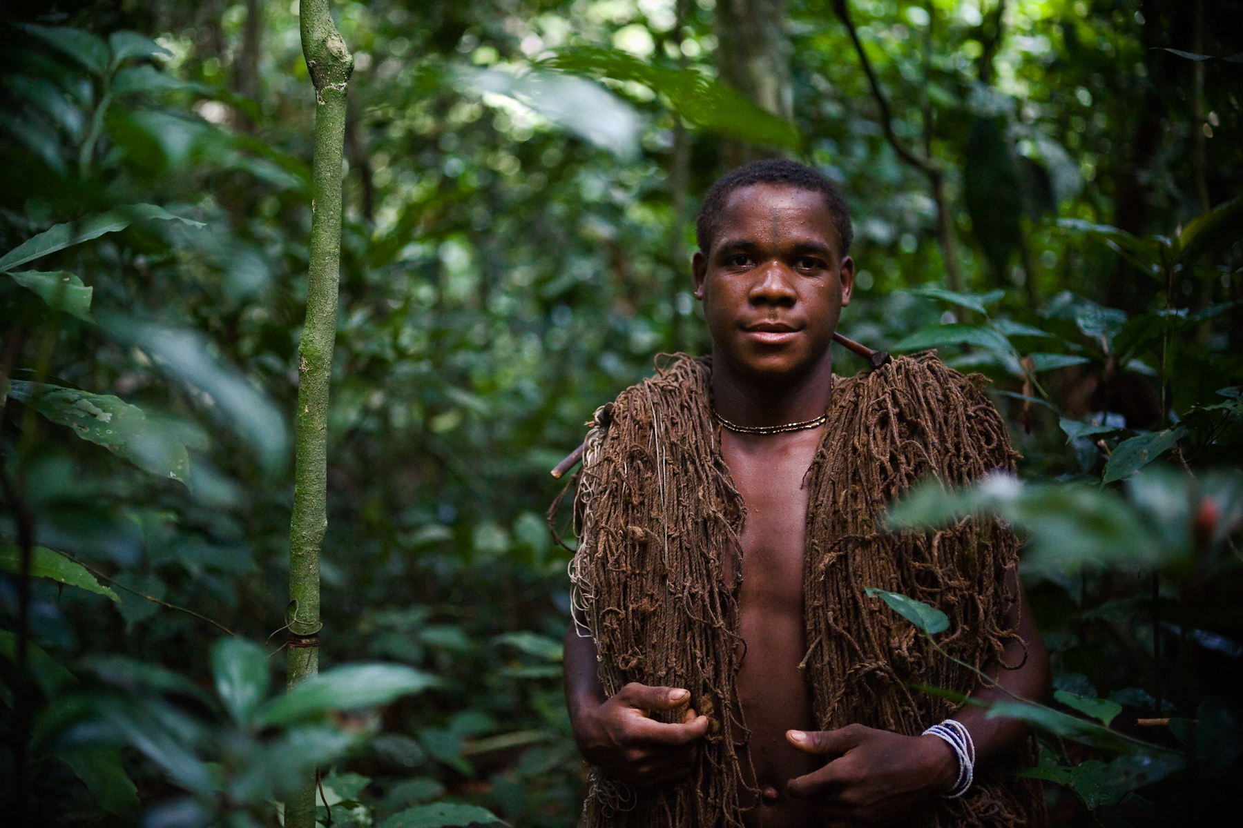 A young Ba'aka man takes a net made from bush string into the forest to go hunting