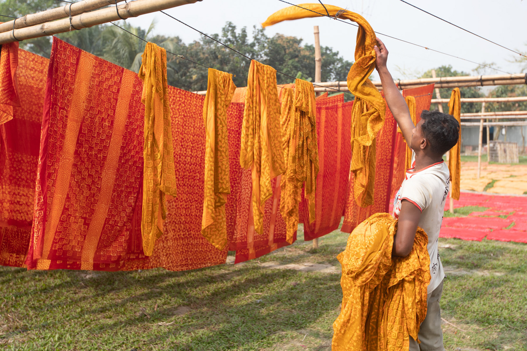 Drying pieces of marigold coloured cloth in rural Bangladesh (image by Yousuf Tushar)