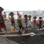 Workers carrying coal off a freight ship (image by Yousuf Tushar)