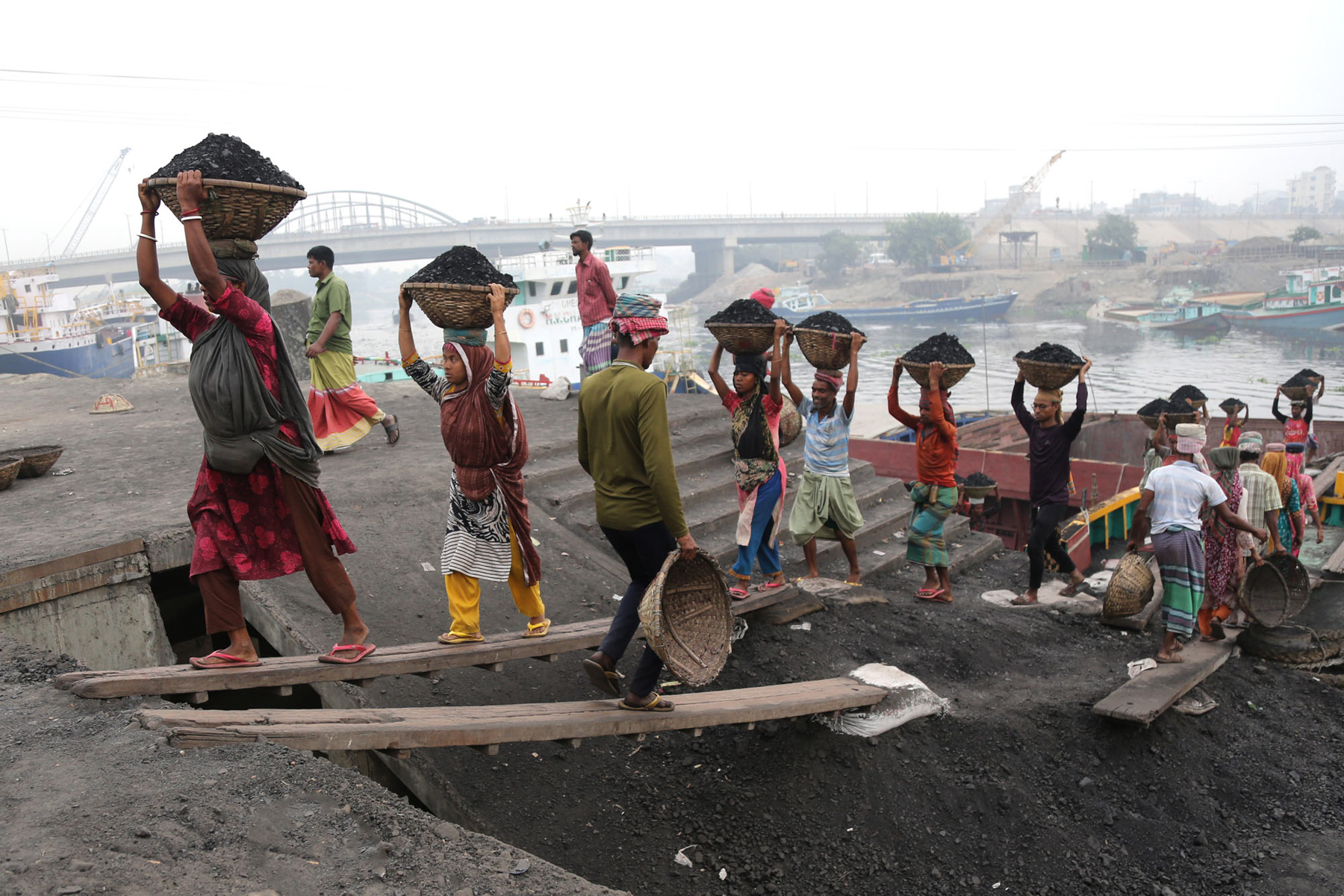 Workers carrying coal off a freight ship (image by Yousuf Tushar)