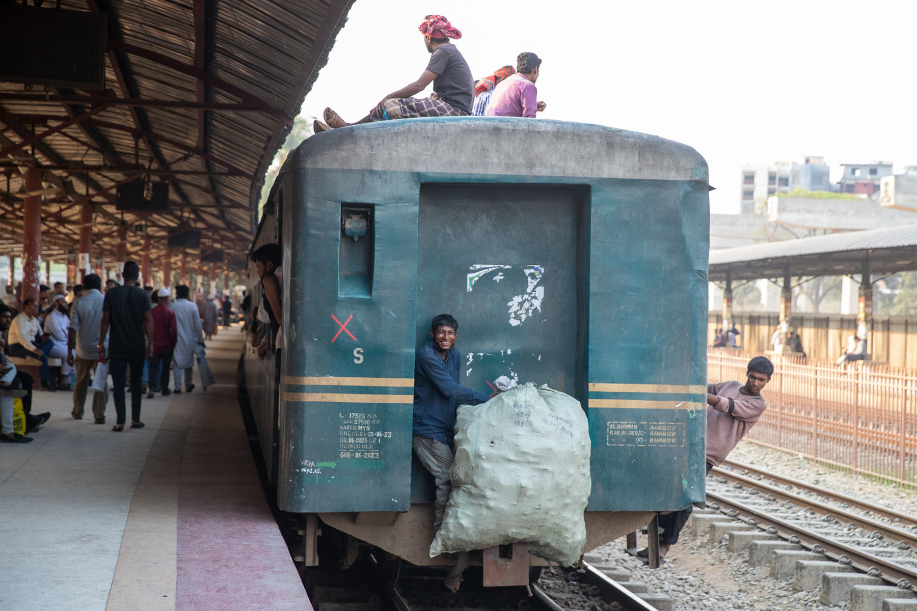 Even the back step of a local train has a smiling passenger (image by Yousuf Tushar)
