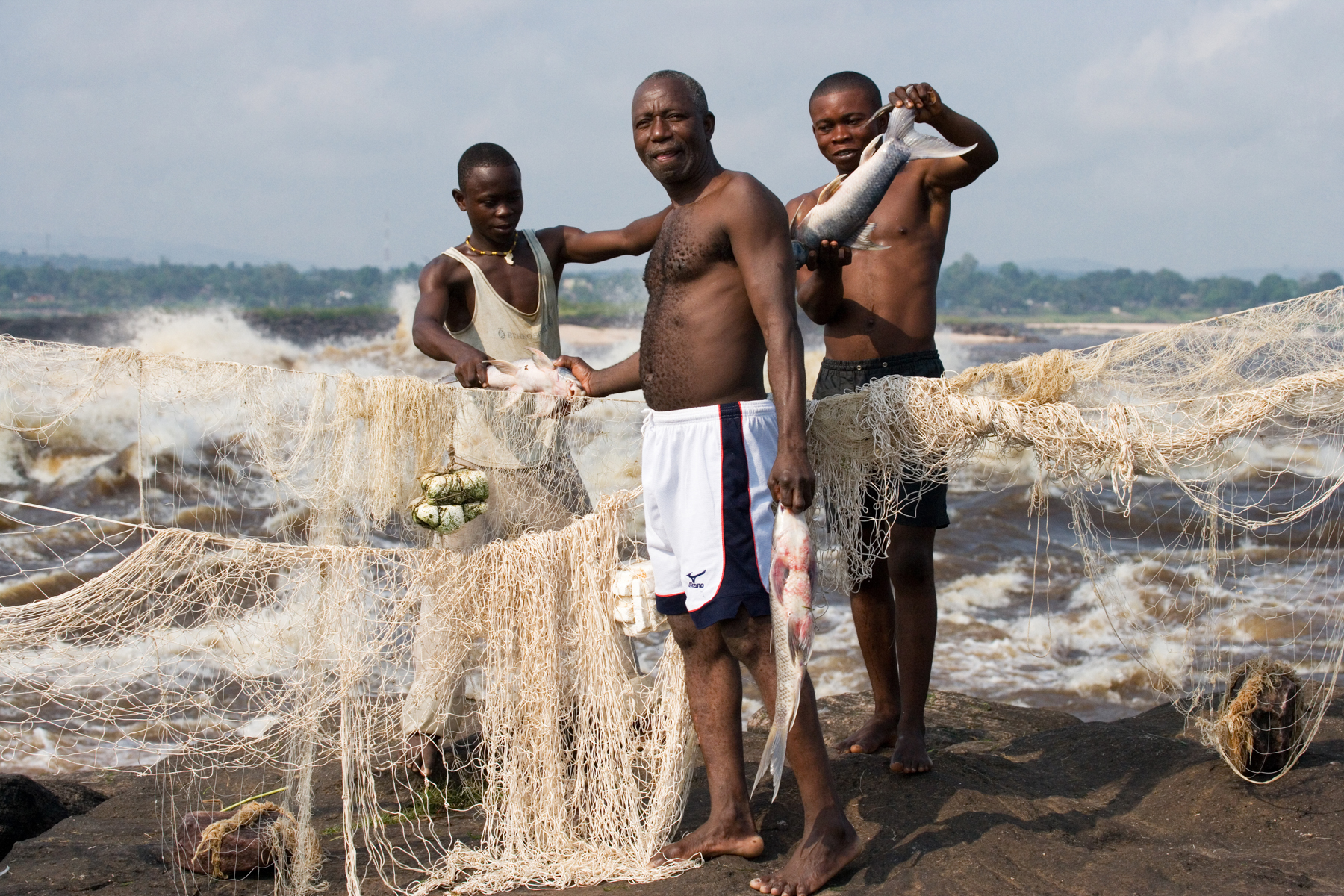 Congolese fishermen net the wild water stretches of the river for fish